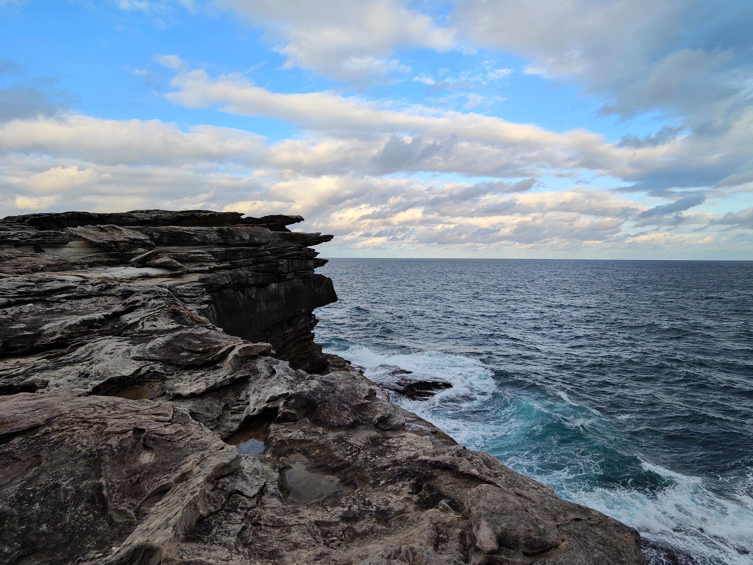 Sandstone cliffs meeting the ocean near Clovelly