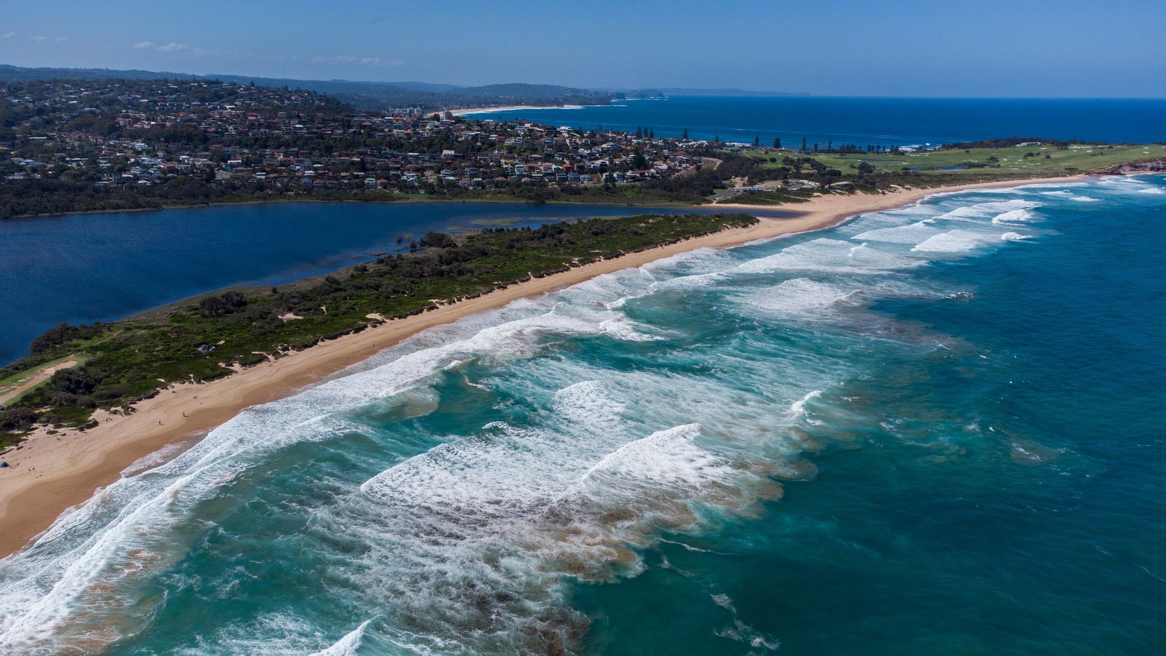 Dee Why Beach and its lagoon from above, surf breaking along the sand