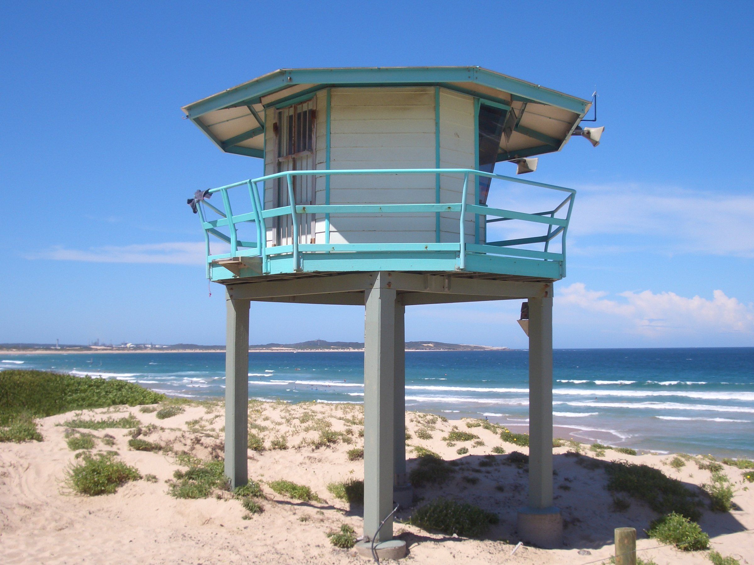 The pale blue lifeguard tower on stilts in the dunes at Elouera Beach