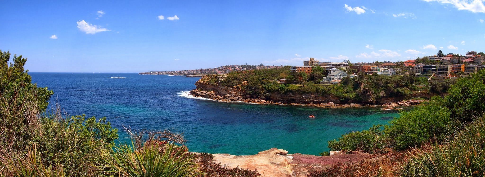Gordons Bay seen from the coastal walk, blue water and houses on the headland beyond