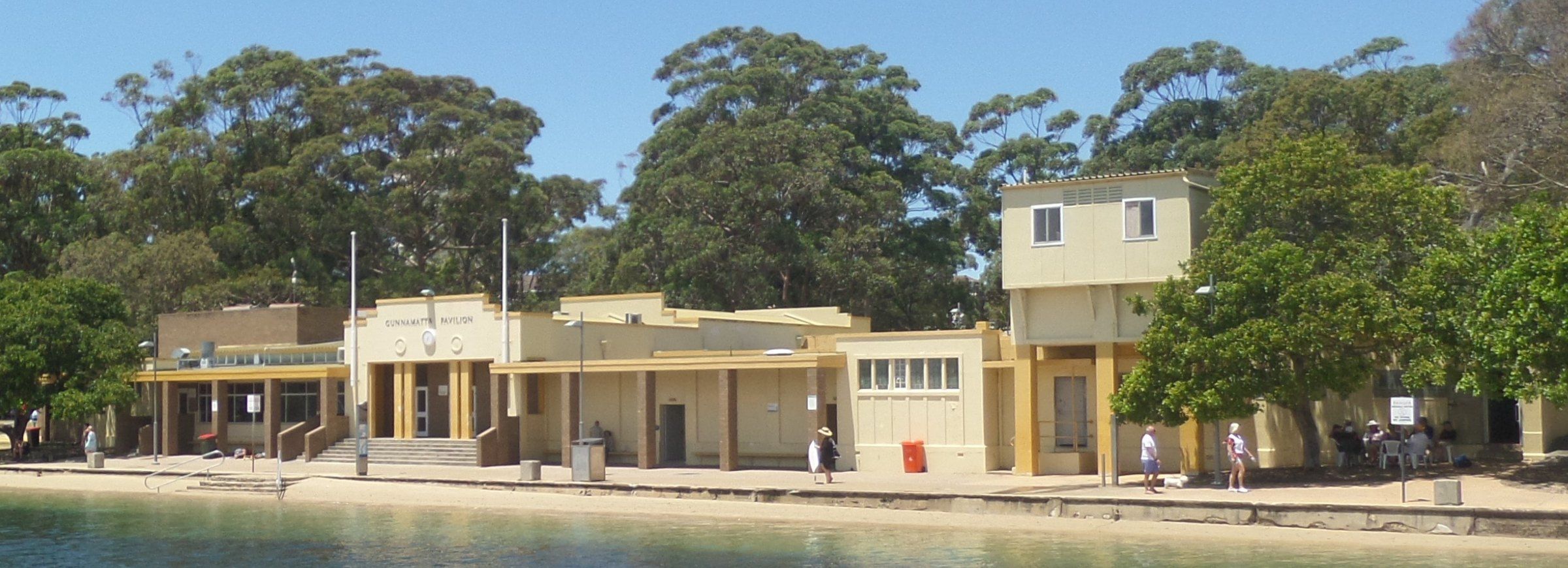 The 1939 Gunnamatta Pavilion seen across the water of the baths, trees behind