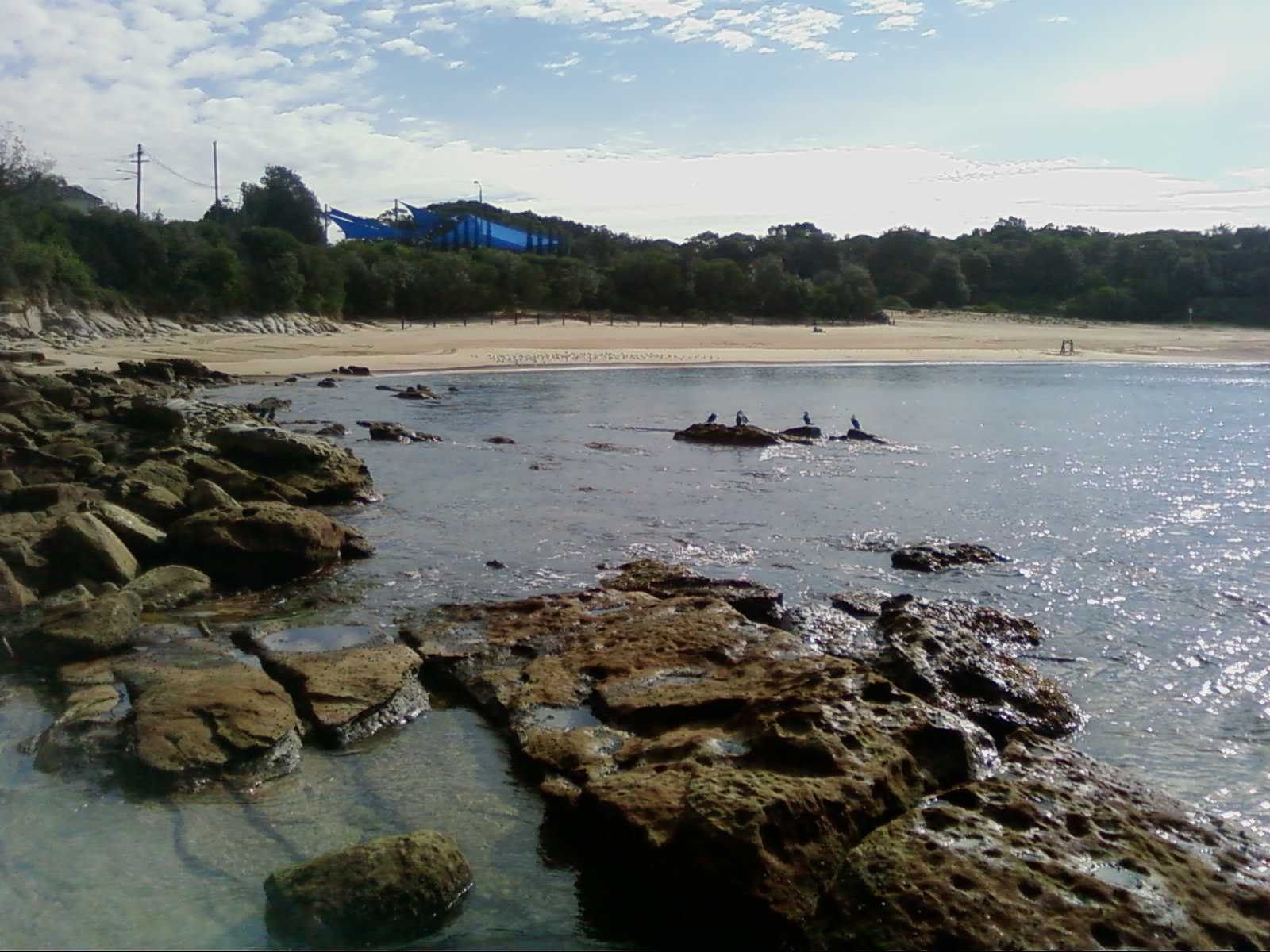 Sandstone rocks and clear shallow water at the edge of Malabar Beach