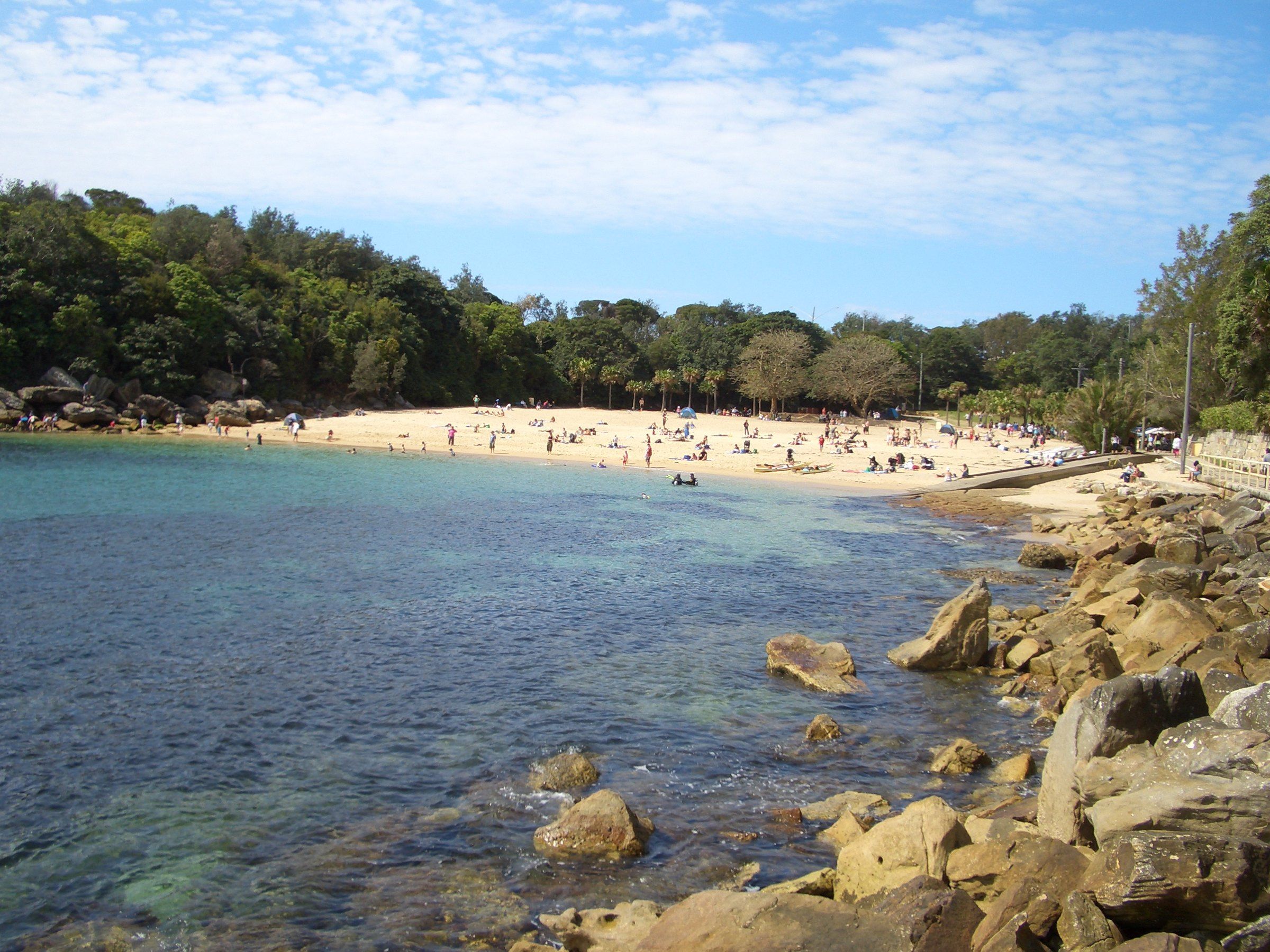 Shelly Beach seen from the rocks at the edge of the cove, clear water over the reef in front