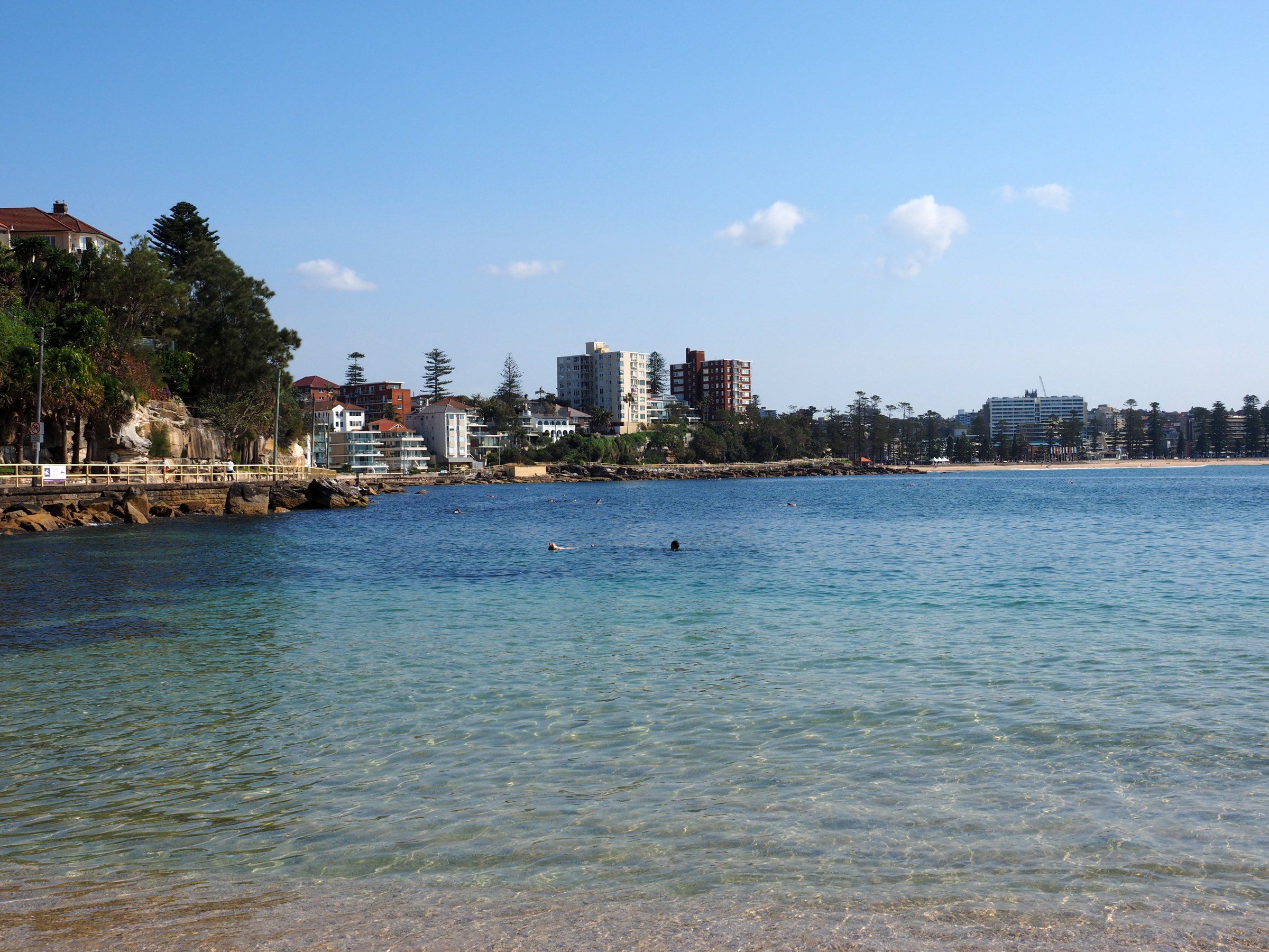 Calm water at Shelly Beach looking back across the bay to the towers of Manly