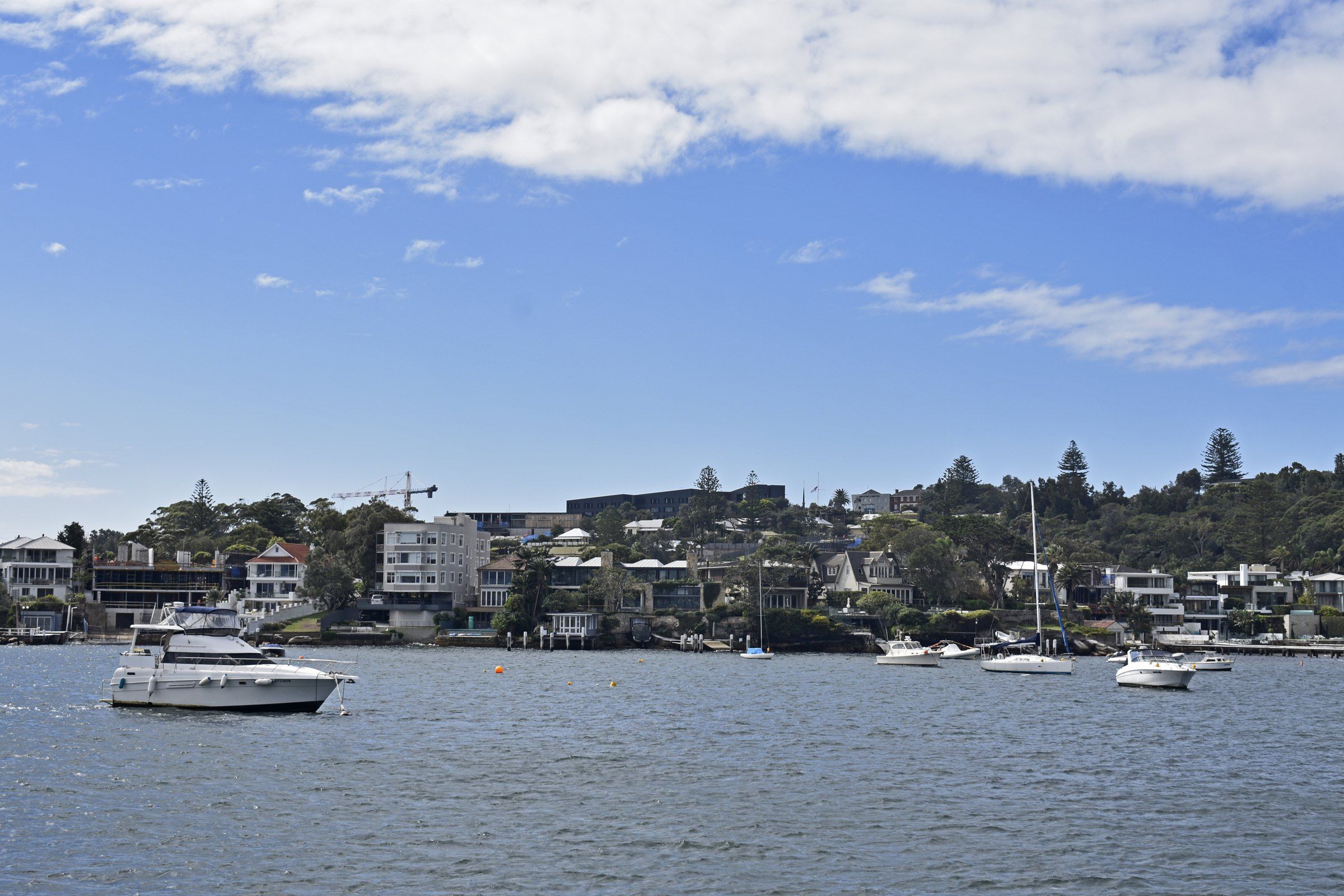 The Watsons Bay shore seen from the water on a sunny day, boats moored off the beach